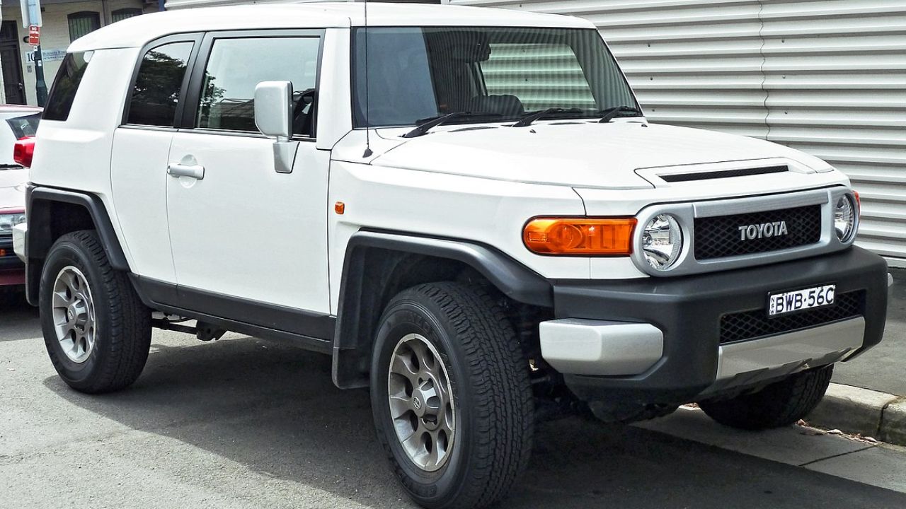 Here is image of White colour Toyota FJ Cruiser which is palaced in side of the road
