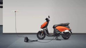 Here is a image of Electric scoter Vida V1 Plus in Orange and balack colour in a charging
